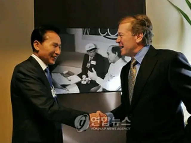 握手を交わす李大統領とチェンバーズ会長＝29日、ダボス（聯合ニュース）