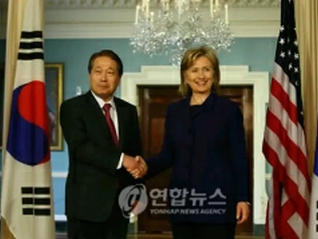 握手を交わすクリントン米国務長官（右）と柳明桓長官＝26日、ワシントン（聯合ニュース）