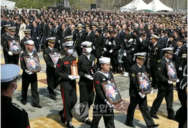 遺族など参列者が見守るなか、犠牲将兵らの英霊が運ばれている＝29日、平沢（聯合ニュース）