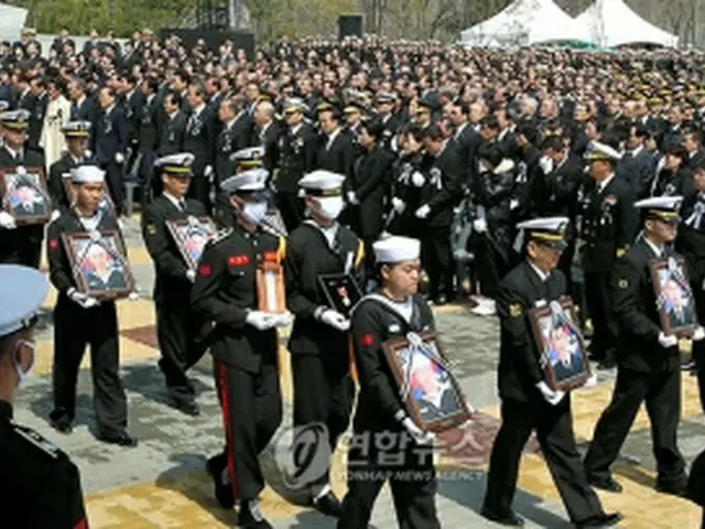 遺族など参列者が見守るなか、犠牲将兵らの英霊が運ばれている＝29日、平沢（聯合ニュース）