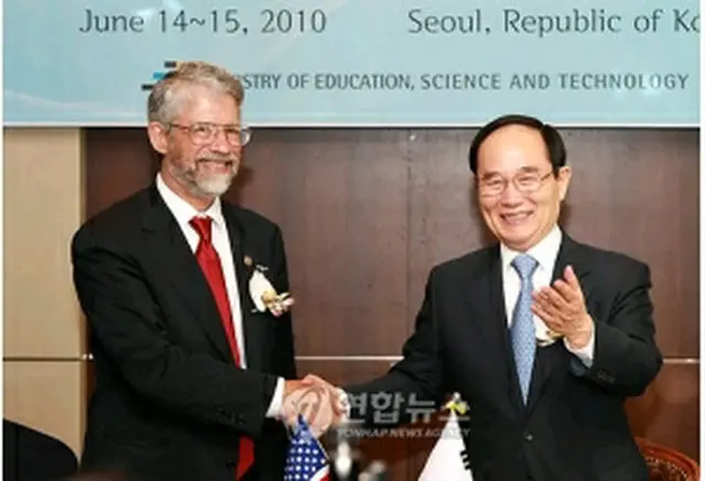 約定締結後、握手を交わす安長官（右）とホールドレン局長（左）（教育科学技術部提供）＝15日、ソウル（聯合ニュース）