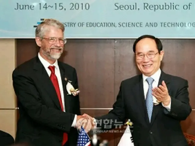 約定締結後、握手を交わす安長官（右）とホールドレン局長（左）（教育科学技術部提供）＝15日、ソウル（聯合ニュース）