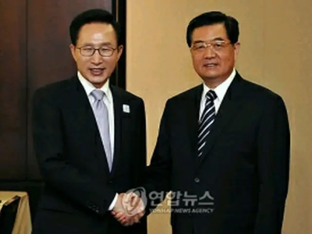 握手を交わす李明博大統領（左）と胡錦濤国家主席＝２７日、トロント（聯合ニュース）