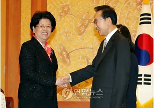 握手を交わす李大統領（右）と陳至立氏＝30日、ソウル（聯合ニュース）