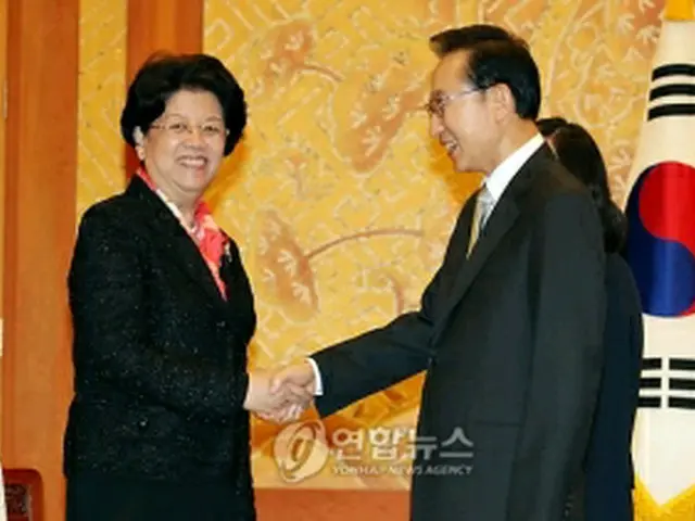 握手を交わす李大統領（右）と陳至立氏＝30日、ソウル（聯合ニュース）