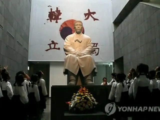 記念館に設置された安重根の座像。国旗に記された「大韓独立」の文字は、指を切断した血で書いたとされる＝26日、ソウル（聯合ニュース）