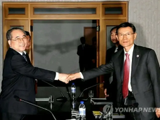 会談で握手を交わす大韓赤十字社の金竜賢事務総長（右）と北朝鮮の崔成益副委員長（共同取材団撮影）＝27日、開城（聯合ニュース）