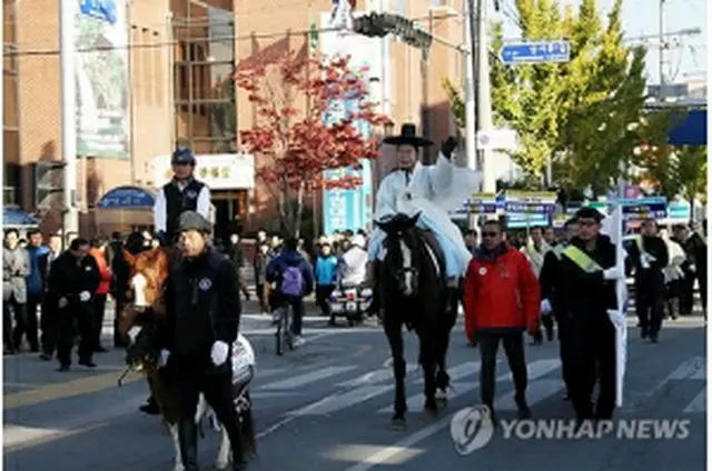 市民に手を振りながら馬で登庁する成百営市長＝27日、尚州（聯合ニュース）