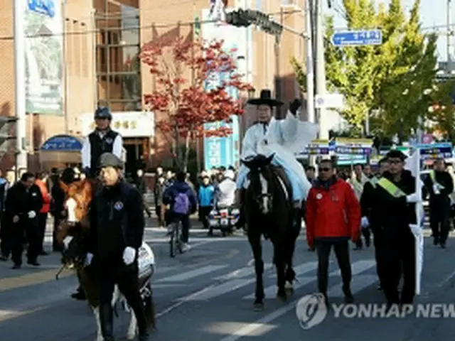 市民に手を振りながら馬で登庁する成百営市長＝27日、尚州（聯合ニュース）