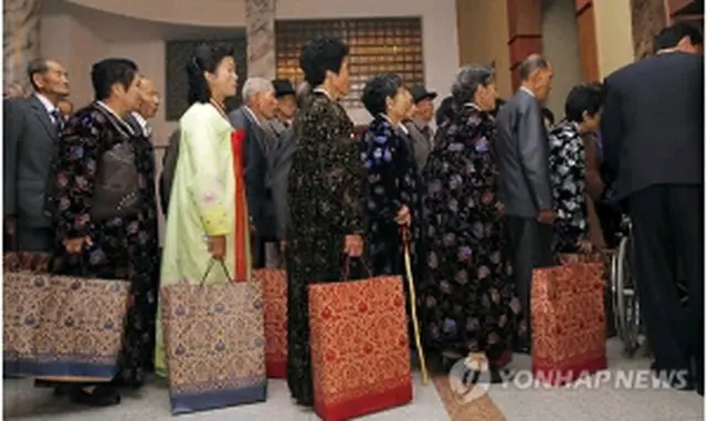 プレゼントが入った紙袋を手に個別面会に向かう北朝鮮側の離散家族＝31日、金剛山（聯合ニュース）
