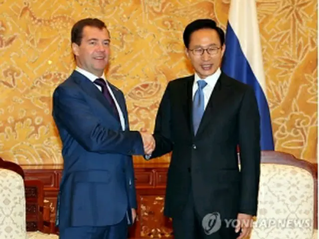 握手を交わす李大統領（右）とメドベージェフ大統領＝10日、ソウル（聯合ニュース）