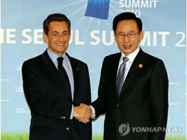 握手を交わす韓仏首脳＝12日、ソウル（聯合ニュース）