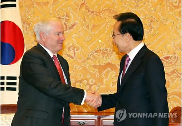 握手を交わす李大統領（右）とゲーツ長官＝14日、ソウル（聯合ニュース）