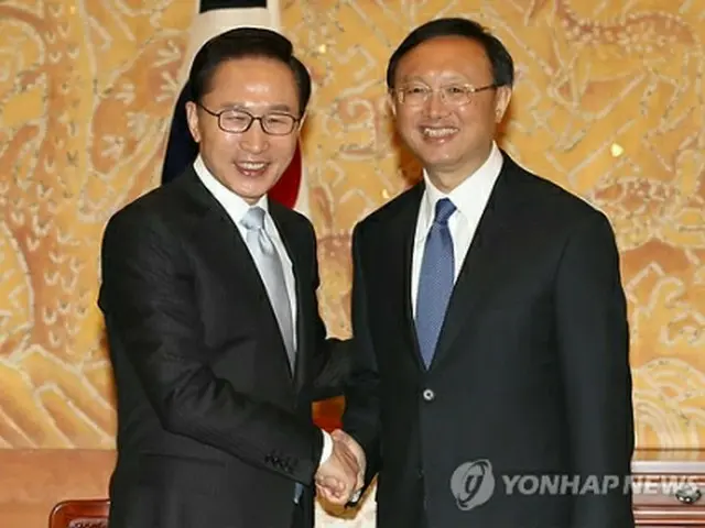 固く握手する李大統領（左）と楊外相＝23日、ソウル（聯合ニュース）