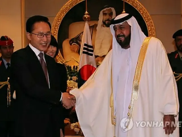握手を交わす両国首脳＝13日、アブダビ（聯合ニュース）