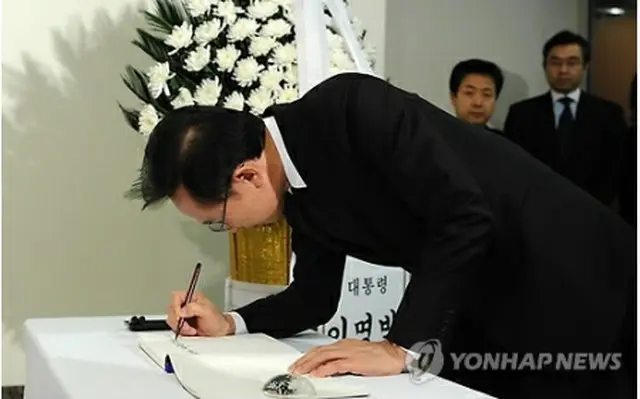 東日本大震災の犠牲者らに弔意を示すため記帳する李大統領＝（聯合ニュース）