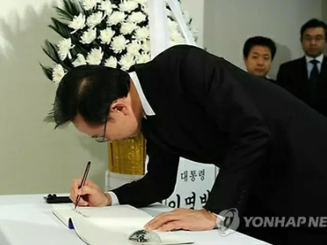 東日本大震災の犠牲者らに弔意を示すため記帳する李大統領＝（聯合ニュース）