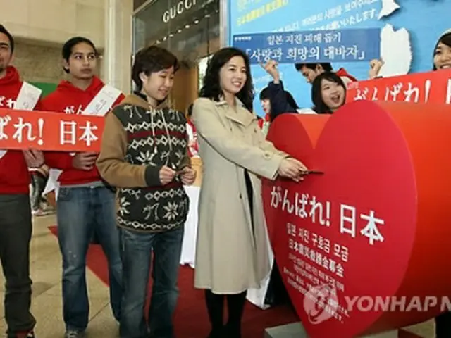 ソウル市内のロッテ百貨店で韓国外国語大学の学生らが東日本大震災を支援するため募金活動を行っている＝20日、ソウル（聯合ニュース）
