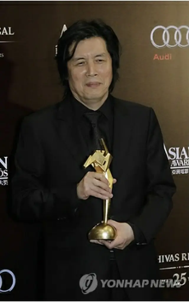 トロフィーを手に笑顔を見せるイ・チャンドン監督＝（AP＝聯合ニュース）