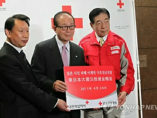 近藤社長（右）に義援金を伝達する柳総裁（中央）＝26日、東京（聯合ニュース）