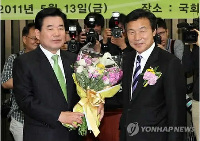 民主党の院内代表に選出された金振杓氏（左）。右は同党の孫鶴圭代表＝１３日、ソウル（聯合ニュース）
