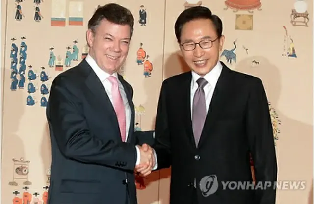 会談の前に握手を交わす両首脳＝15日、ソウル（聯合ニュース）