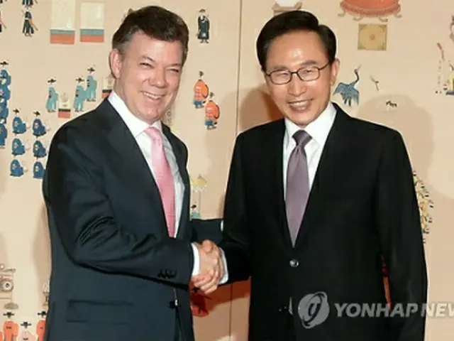 会談の前に握手を交わす両首脳＝15日、ソウル（聯合ニュース）