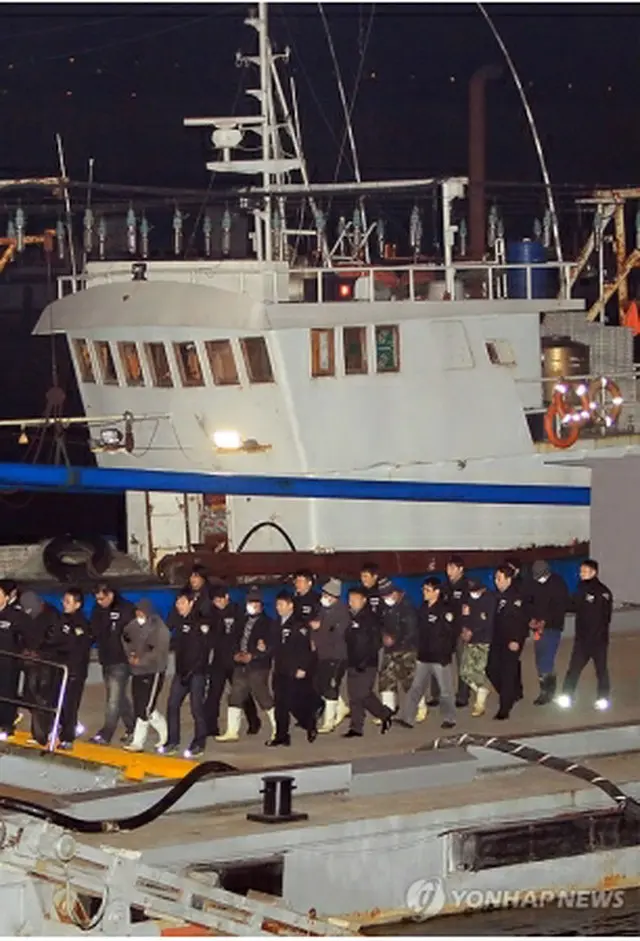 死傷した海洋警察官が取り締まりに当たっていた中国漁船が１３日未明、仁川海洋警察に移送された。前方は漁船乗組員ら＝１３日、仁川市（聯合ニュース）