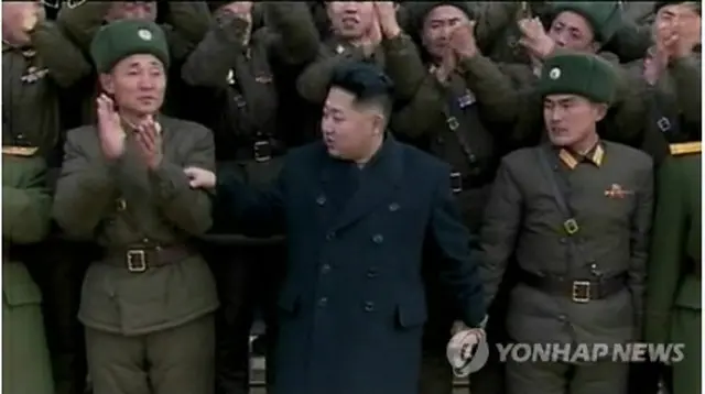 部隊での記念撮影で、兵士の手を取る正恩氏＝4日、ソウル（朝鮮中央テレビ＝聯合ニュース）
