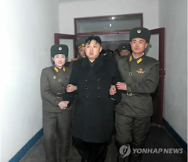 視察で訪れた軍部隊で兵士らと腕を組む正恩氏（中央）＝（聯合ニュース）