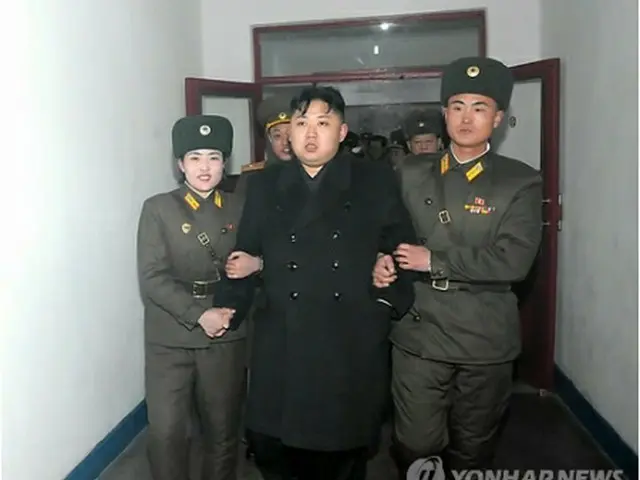 視察で訪れた軍部隊で兵士らと腕を組む正恩氏（中央）＝（聯合ニュース）