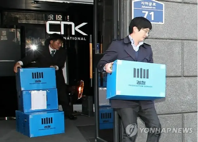 ソウル地検関係者が２６日、ＣＮＫ本社を家宅捜索し、押収した資料を運んでいる＝（聯合ニュース）