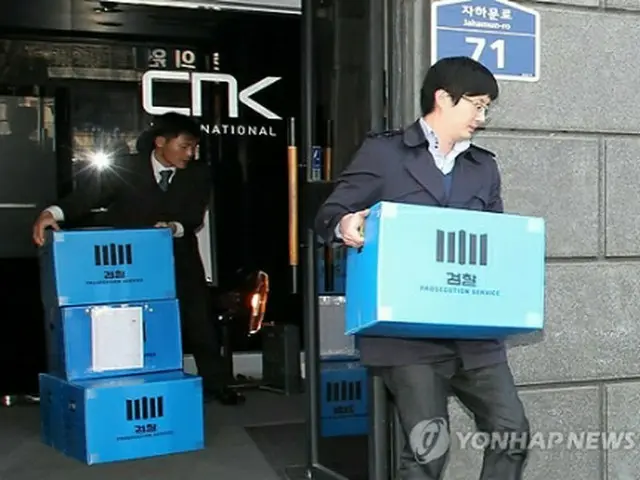 ソウル地検関係者が２６日、ＣＮＫ本社を家宅捜索し、押収した資料を運んでいる＝（聯合ニュース）