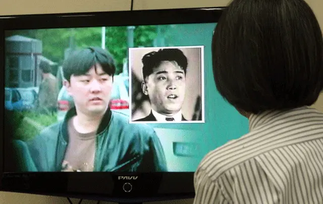 １５日、日本フジテレビで放送された北朝鮮金正日国防委員長の次男正哲氏と推定される人物（左）。フジテレビがドイツで活動中の姿を撮ったものだ。テレビ画面の中央右側は金正哲の祖父ある故金日成北朝鮮主席。（ＭＢＣＴＶ撮影＝YONHAP NEWS）