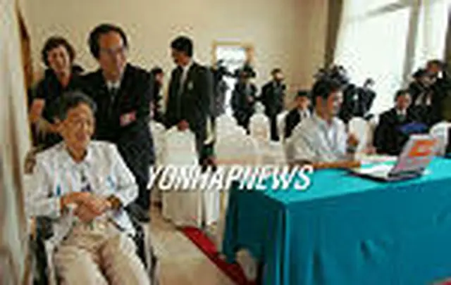 会見場へ入場する金英男さん