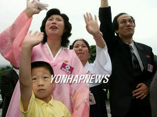 母親の崔桂月さんに金英男さん（右）と妻のパク・チュンファさんら家族が手を振って別れを告げた＝３０日、金剛山（聯合）