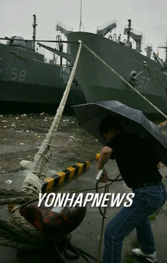 太いロープでつながれる大型軍艦。慶尚南道の馬山港＝１０日、馬山（聯合）