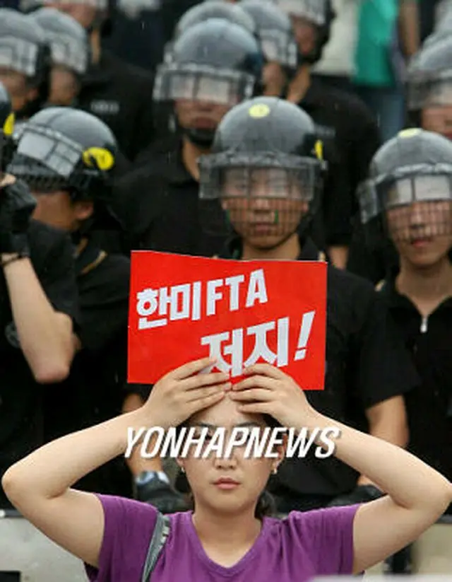 記者会見を進めようとする反韓米ＦＴＡ団体の会員と、警備に立つ警察＝１０日、ソウル（聯合）