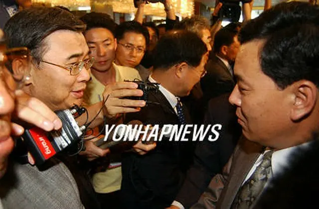 終結会議後に別れの握手を交わす李鍾ソク長官（左）と権虎雄内閣責任参事＝１３日、釜山（聯合）