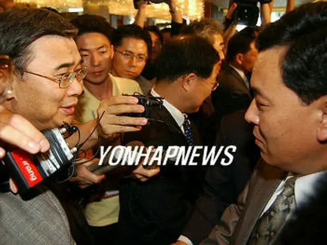 終結会議後に別れの握手を交わす李鍾ソク長官（左）と権虎雄内閣責任参事＝１３日、釜山（聯合）