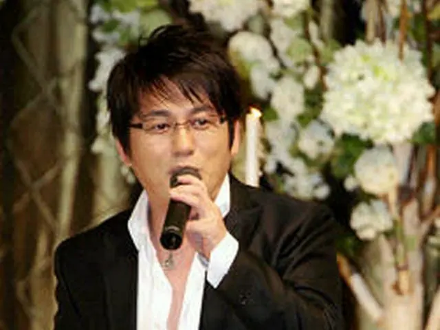 友人の結婚式で歌うシン・スンフン＝6月、ソウル(聯合)