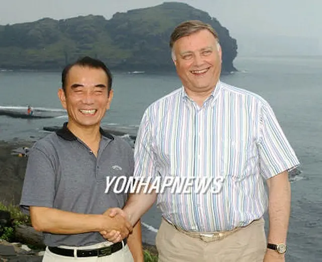 韓国鉄道公社の李哲社長（左）とポーズを取るロシア鉄道公社のヤクーニン社長＝１９日、西帰浦（聯合）
