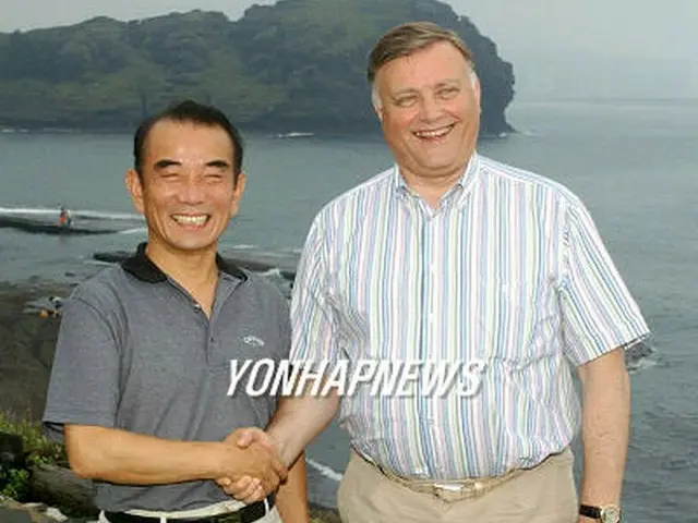 韓国鉄道公社の李哲社長（左）とポーズを取るロシア鉄道公社のヤクーニン社長＝１９日、西帰浦（聯合）