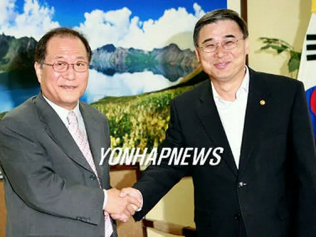 会談を終え、丁世鉉元統一部長官と握手を交わす李鍾ソク長官＝8日、ソウル（聯合）