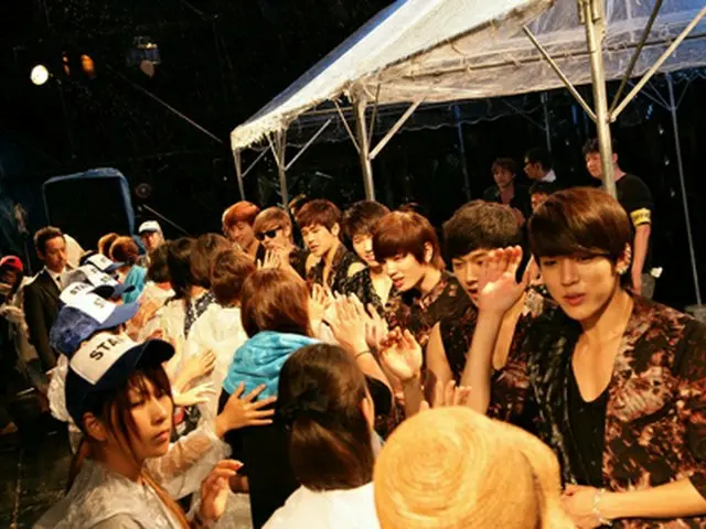 雨の中、会場に足を運んだファンたちとハイタッチする「INFINITE」