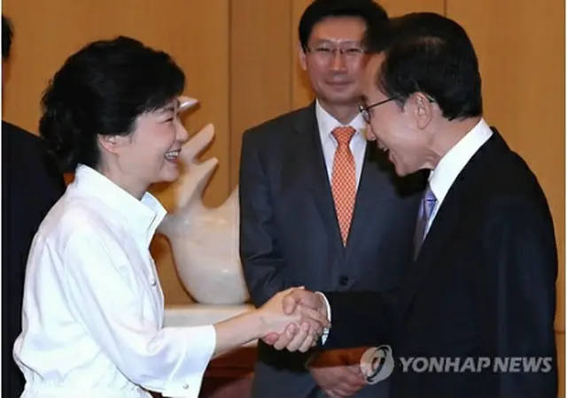 ９月に行われた会談で握手を交わす李大統領（右）と朴氏＝（聯合ニュース）