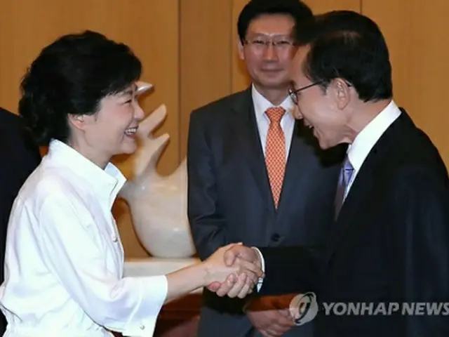 ９月に行われた会談で握手を交わす李大統領（右）と朴氏＝（聯合ニュース）