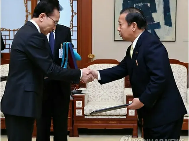 二階氏（右）に勲章を授与する李大統領＝30日、ソウル（聯合ニュース）