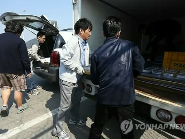 開城工業団地に入居する韓国企業の関係者が帰還後、トラックに荷物を積み込んでいる＝27日、坡州（聯合ニュース）