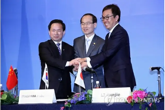 共同声明に署名した後に握手する尹成奎環境部長官（中央）ら＝６日、北九州（聯合ニュース）